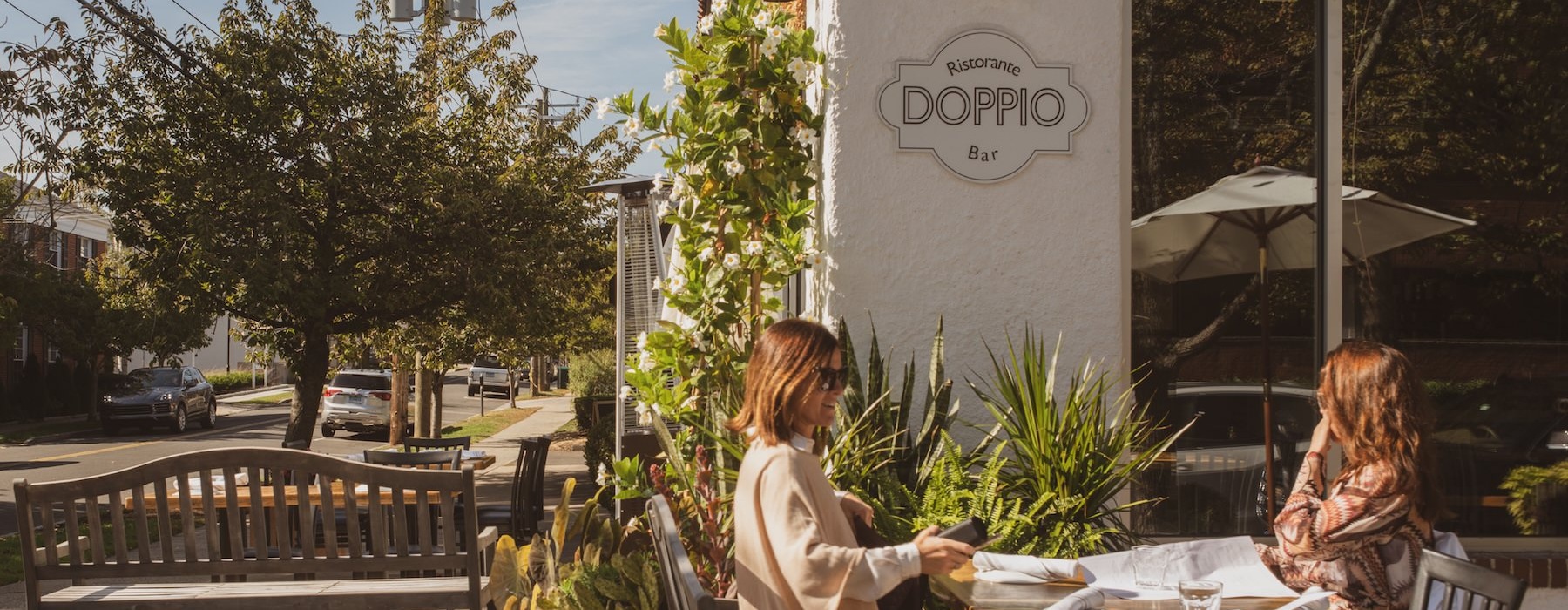 a couple of women sitting at a table outside